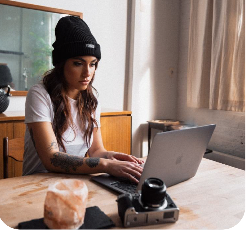 Sarah, a hospital patient persona, working on her laptop in bed